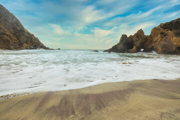 Pfeiffer Beach in Big Sur is an incredibly picturesque beach, beautiful landscape on the Pacific coast, rocks, sand, ocean and sky. Concept, vacation, photo for postcards, tourist and travel guide.