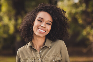 Photo of attractive carefree wavy hairdo dark skin lady toothy smile look camera enjoy weekend...
