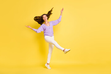Full length photo of young cheerful girl happy positive smile go walk wear casual outfit isolated over yellow color background
