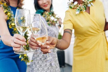 Close-up image of Christmas party guests toasting with glasses of champagne