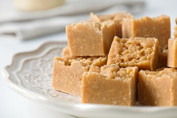 Homemade fudge cut into cubes on plate on white kitchen counter
