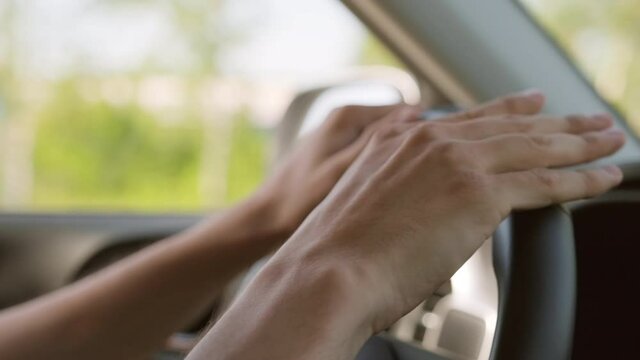 Close-up shot footage of unrecognizable young mans hands driving car drumming steering wheel