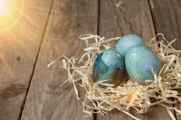 Colorful Easter eggs in a nest on a wooden table. Easter concepts
