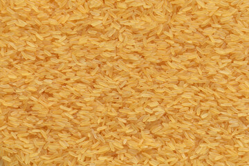 Parboiled yellow rice background or texture.