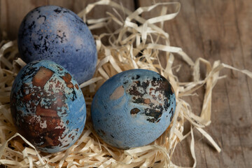 Fototapeta na wymiar Colorful Easter eggs in a nest on a wooden table. Easter concepts