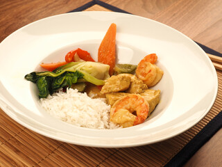 Red Thai curry with chicken and shrimps with fried vegetables and rice