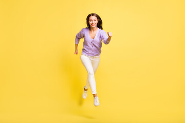Fototapeta na wymiar Full length body size view of attractive cheerful sporty girl jumping running marathon isolated over bright yellow color background