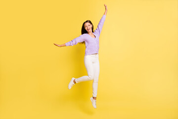 Fototapeta na wymiar Full length body size view of carefree cheerful girl jumping having fun rest party isolated over bright yellow color background