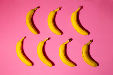 yellow ripe juicy bananas on a pink background