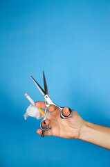 a woman's hand with a bandaged finger holds scissors and a lit cigarette