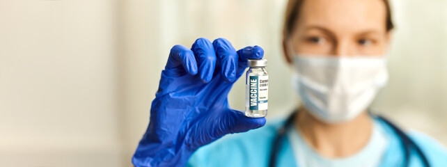 Doctor, nurse hand in blue gloves holding coronavirus covid-19 vaccine