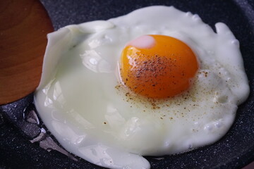 Fried eggs on the pan and peppered on top