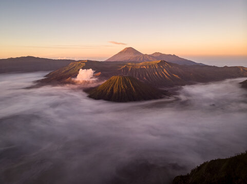 Aerial view of Mount Bromo surrounded with clouds at sunset, an active volcano near Probolinggo town, East Java, Indonesia.