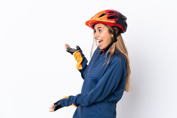 Young hispanic cyclist woman isolated on white background with surprise expression while looking side