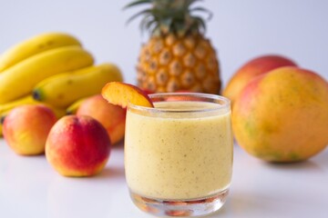 Healthy fruit smoothie in glass in front of fresh fruit