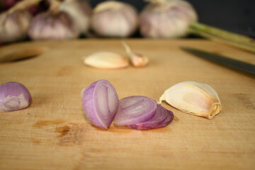 garlic onion and dry red chilli on wooden cutting board in kitchen