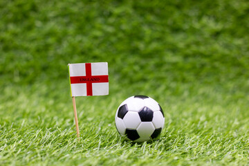 Fototapeta premium Soccer ball with England Flag on green grass background