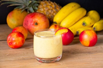 Healthy fruit smoothie in glass in front of fresh fruit