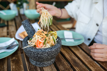 Woman having papaya salad in a restaurant closeup