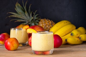 Healthy fruit smoothie in glass in front of fresh fruit