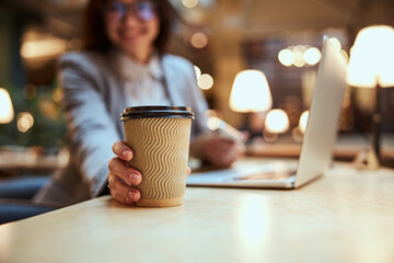 Focused photo on female hand taking paper cup