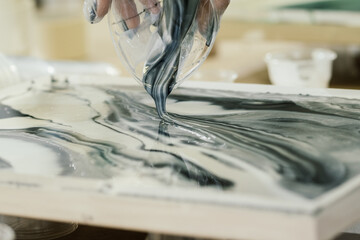 at the fluid art workshop, colored resin is poured onto resin art painting