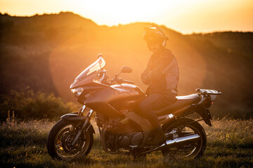 Man on his motorbike riding into sunset