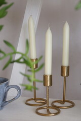 white wax candles in brass candlesticks
