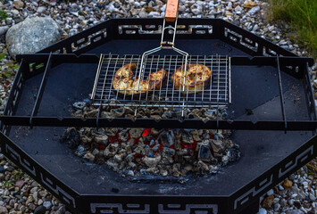 Grilled fish steak. Сooking  on the grill,  metal fire bowl on the coals in the open air. Barbeque in the garden