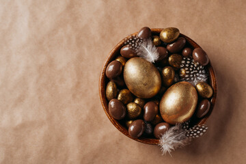 Easter concept with golden eggs and candy sweet on yellow background