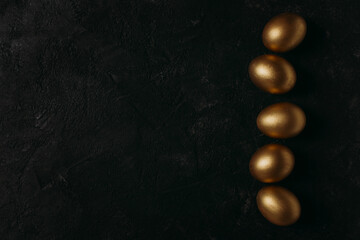 Easter concept card with golden eggs and candy sweet frame falt lay on black background