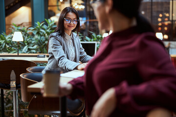 Joyful young office worker staring at her laptop