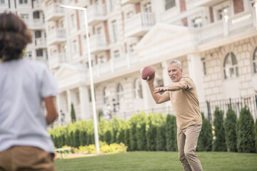 Dark-haired boy playing a ball with his dad