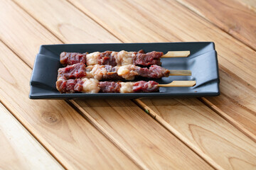 fresh raw meat pork beef sliced on square plate isolated on wooden background, shabu, hot pot ingredients