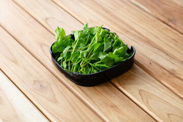 fresh raw celery sliced on square plate isolated on wooden background, shabu, hot pot ingredients