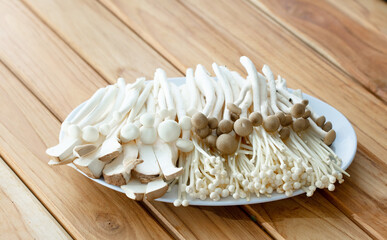 fresh raw mushroom  sliced on square plate isolated on wooden background, shabu, hot pot ingredients