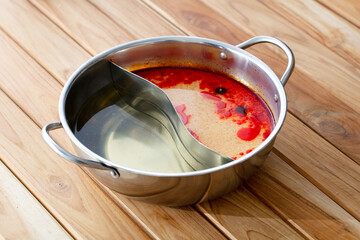 fresh raw Broth pot sliced on square plate isolated on wooden background, shabu, hot pot ingredients