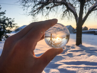 Schneekugel in einer Winterlandschaft bei Sonnenuntergang