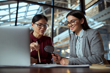 Cheerful female person consulting with her colleague