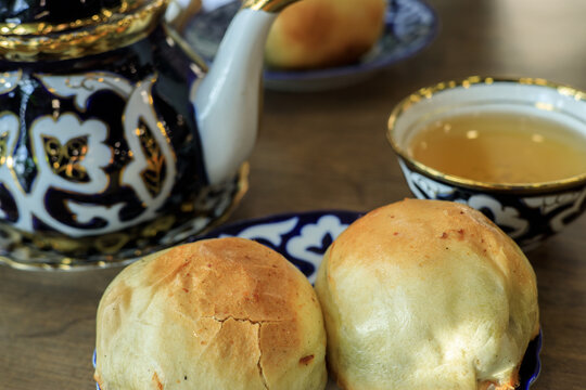 Traditional uzbek ceramic teapot and food somsa