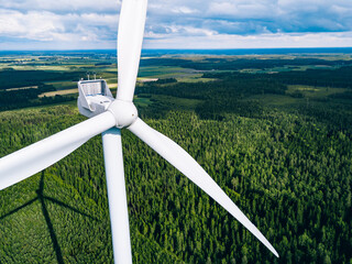 Aerial view of windmills in green summer forest in Finland close up.