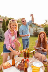 Friends having fun at backyard barbecue party