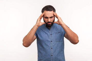 Fototapeta premium Unhappy frustrated bearded man massaging temples feeling headache, suffering migraine or high blood pressure, trying to concentrate. Indoor studio shot isolated on white background