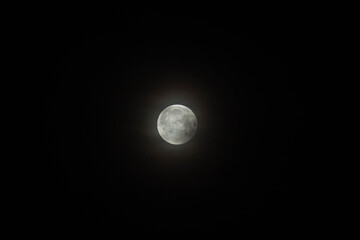 Full moon glowing with well-available craters over black sky