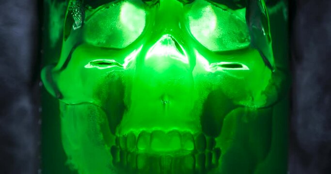 Glowing Green Skull. Ice skull glowing with a cold blue light in the vapor of evaporating gas. Slow Motion 120 fps