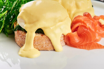 Toast with salmon, poached egg and hollandaise sauce.. Close up