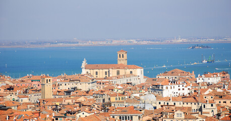 Fototapeta na wymiar Venetian roof cityscape and lagoon at background. Venice, Italy.