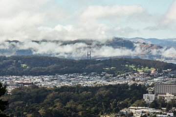 Fototapeta na wymiar A beautiful panorama of San Francisco downtown and the famous Golden Gate Bridge in the fog as seen from the Twin Peaks, California - United States of America aka USA