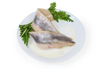 Pickled herring fillets on dish with fresh parsley