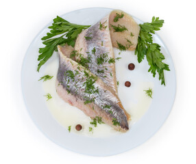 Pickled herring fillets with fresh parsley and dill on dish